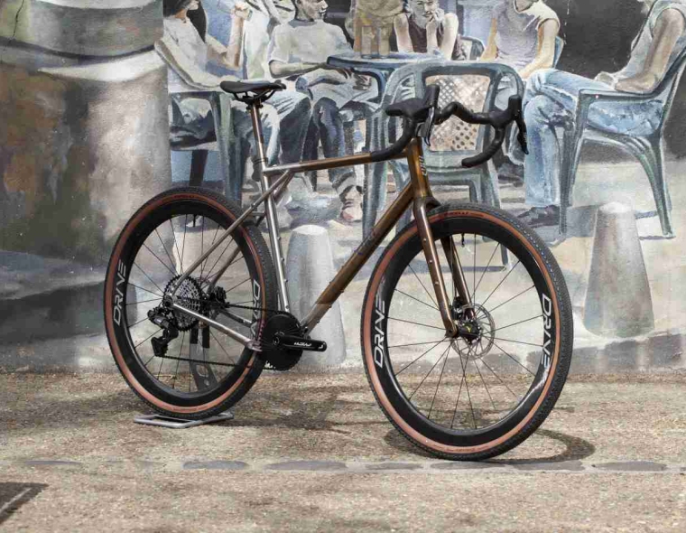 Titanium City Gravel Bike with Carbon Spoke Wheels on a French Street